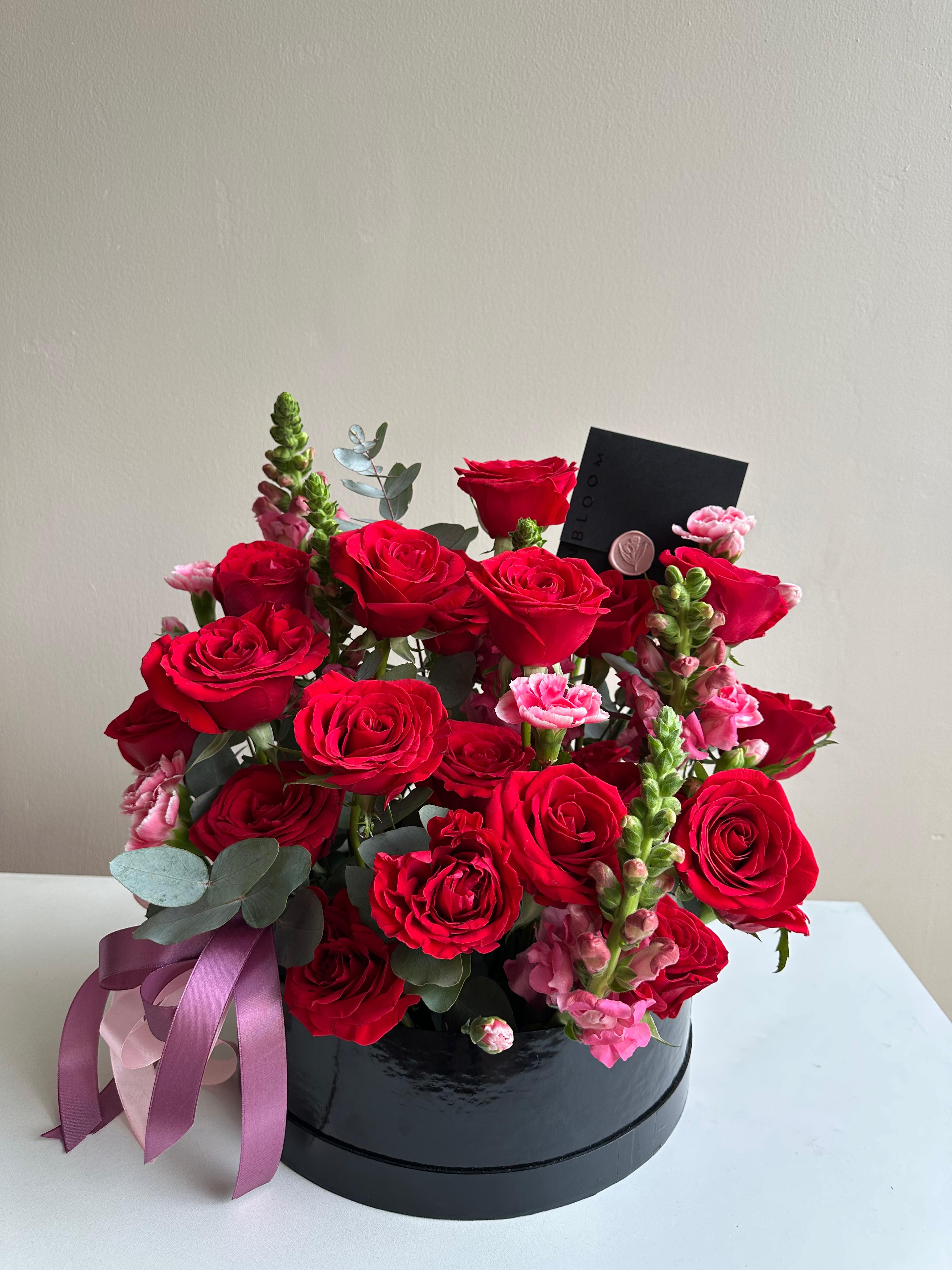 Arreglo floral contemporáneo con rosas, dragones y eucalipto en caja — estilo delicado | InBloom Guatemala